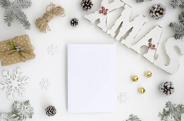 Mockup Weihnachtsgrußkarte Draufsicht und Weihnachtsbuchstaben aus Holz, flach auf weißem Hintergrund mit Geschenkschachtel, Tannenzapfen, Tannenzweig, leeres Notizbuch mit Platz für Ihren Text — Stockfoto