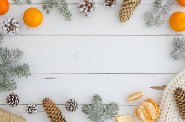 şık yeni yıl, Xmas, neşeli Noel çerçeve süsleri, çam kozalakları ve şube, örme atkı, Hediyelik, Portakal Mandalina Beyaz ahşap plakalar tablo üstten görünüm üzerinde. Trendy rahat tasarım arka plan .