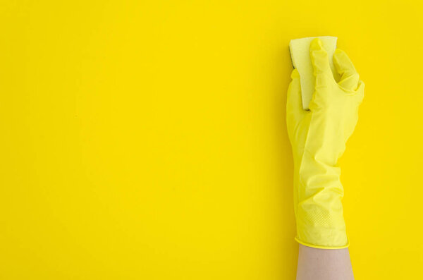 woman Hand in yellow glove with sponge on yellow background. Flat lay copy space