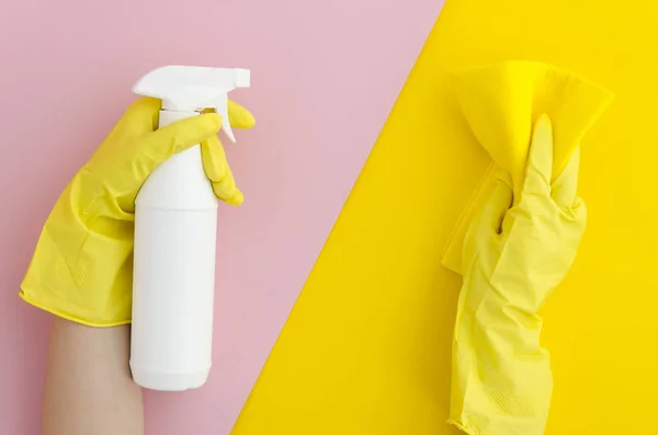 Female hands in yellow rubber gloves hold a spray for cleaning windows and cleaning cloth on a bright split color background. The concept of cleaning the service. Flat lay, Top view. Mock up — Stock Photo, Image