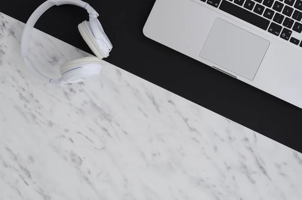 Top view of laptop notebook , headphone on split color background black and marble. Copy space mock- up create idea for business or design. Relax time listen song. flat lay