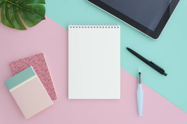 Şık minimalist Ofis Resepsiyon çalışma alanı boş tablet ile alay defter, kalem, fırça, renk arka plan Böl pembe ve mavi çift ton üzerinde izole. Düz yatıyordu stil üstten görünüm.