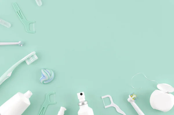 Composizione laica piatta con spazzolini da denti manuali e prodotti per l'igiene orale su sfondo menta Stomatologo modellare spazio copia. Cura dei denti Concetto telaio — Foto Stock