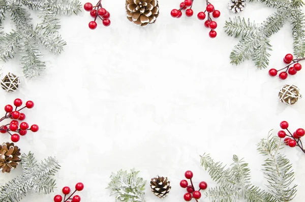 Jul stomme kreativa av kottar, röda bär och fir grenar på vit bakgrund med ledigt utrymme för bokstäver. Vinter koncept. Platt låg. Ovanifrån. — Stockfoto