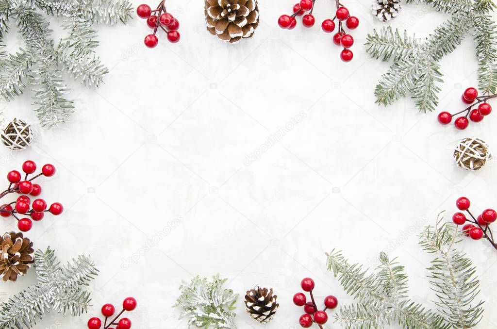 Christmas creative frame made of cones, red berry and fir branches on white background with free space for lettering. Winter concept. Flat lay. Top view.