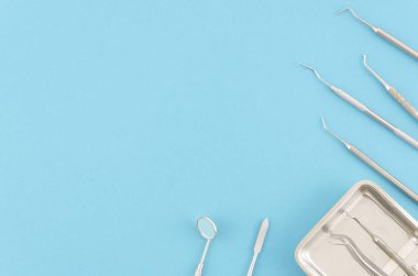 Diş Kliniği diş hekimi düz yatıyordu kavramı. Profesyonel stomatolog araçları, dişlerle ilgili sağlık kaygı. Açık mavi renkli üstten görünüm kopya alanı. Diş çürüğü tedavi