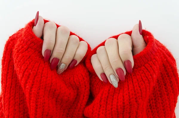 Hermosas uñas de dedo hembra con uñas rojas de cerca en suéter de punto rojo. Manicura perfecta — Foto de Stock