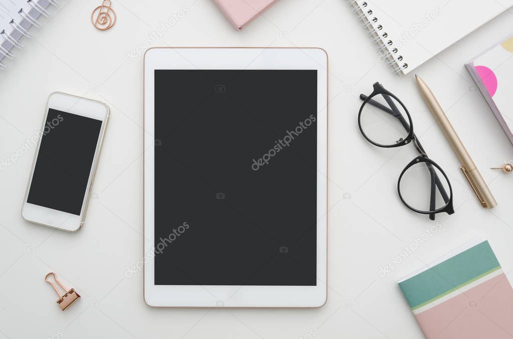 Mockup. Digital tablet with blank screen, smartphone and notepad on table. Woman office workspace. Blog concept.