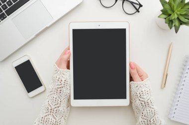 Tablet ve smartphone mockup beyaz Ofis Masası'nı kullanarak iş kadını el atış yukarıdan kırpılmış. Boş ekran cep telefonu grafik görüntü montajı için