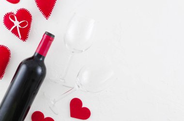 Sevgililer günü tebrik kartı ile şarap şişesi yat, kalpleri ve bardağı beyaz arka plan üzerinde hissetti. Üstten görünüm ile selam alan. Mock-up