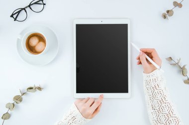 Grafik tablet boş ekran yakınındaki Stylus kalem tutan kadın el. Boş ekran mockup. Çizim, resim, çizim Tasarımcısı. Siyah tablet dokunmatik ekran mockup. Kahve ile en az temiz masaüstü kavramı
