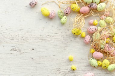 Renkli yumurta ile mutlu Paskalya kavramı tatil kartı. Rustik beyaz ahşap arka planda köşe sınırı