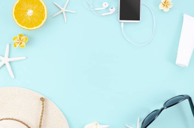 Yaz konsepti düz mavi arka planda turuncu, şapka, güneş gözlüğü ve akıllı telefon ile çerçeve yatıyordu. Üst görünüm. Düz yatma
