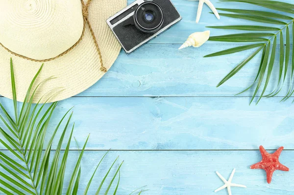 Top view beach accessories flyer, palm leaf branches and wicker hat on blue planks frame. Summer flat lay background — Stock Photo, Image