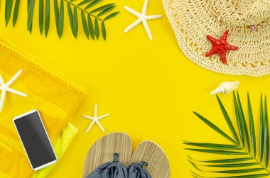 Üst görünüm yaz plaj aksesuarları. Tropikal palmiye yaprağı dalları ile çerçeve banner, metin alanı ile sarı arka planda havlu ve plaj terlikleri. Yaz düz arka plan yatıyordu