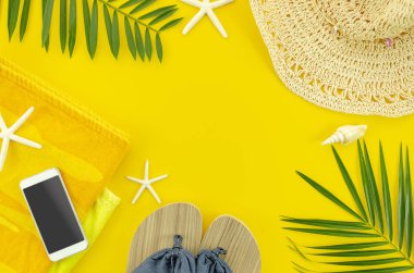 Daire Plaj aksesuarları yatıyordu. Sarı arka planda tropikal palmiye yaprağı dalları, havlu, cep telefonu ve plaj terlikleri ile Flyer.