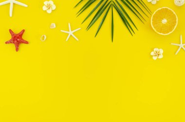 Daire Palmiye, yıldız balıkları ve portakallar ile sarı arka planda afiş için boş alan ile köşe çerçevesi plaj kavramı yatıyordu