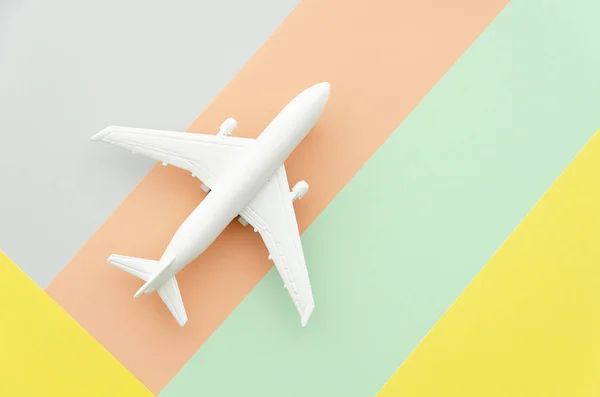 Flat lay design travel concept with plane on blue, blue and peach background with copy space. Runway, fly choose your direction