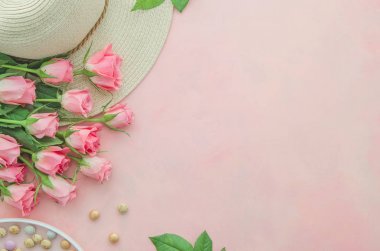 Üst görünüm yaz kadın bir hasır şapka, tatlılar ve pembe gül çiçekleri ile pembe masaüstü çalışma alanı kavramı. Metin için alan kopyalama