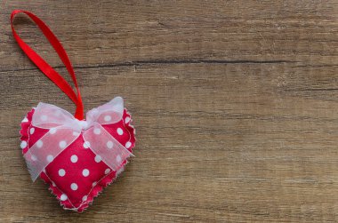 Düz beyaz nokta ve yay ve metin için kopya alanı ile ahşap arka plan ile kırmızı yastık kalp yatıyordu