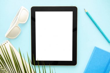 Üst görünüm mockup yaz çalışma masası. Not defteri, güneş gözlüğü ve palmiye yaprağı ile Tablet pc