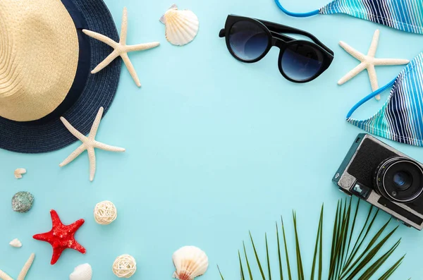Widok z góry lato wakacje morze koncepcja. Damskie okulary przeciwsłoneczne i bikini z liści palmowych i Kapelusz Słomkowy na niebieskim tle — Zdjęcie stockowe