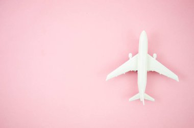 Üst görünüm modeli uçak, pembe pastel arka plan üzerinde uçak oyuncak. Seyahat afişi için kopya alanı ile düz yatıyordu