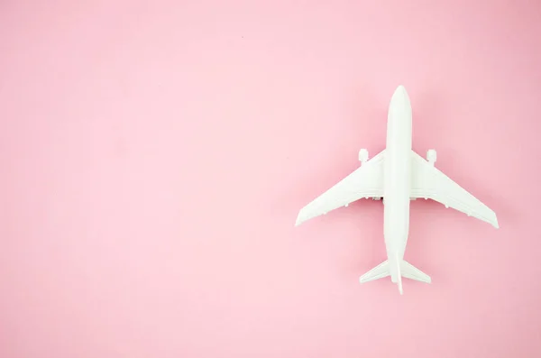 Top view model plane, airplane toy on pink pastel background. Flat lay with copy space for travel banner