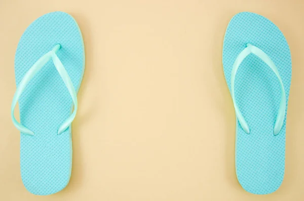 框架模型蓝色海滩拖鞋隔离在柔和的米色背景。带复制空间的顶视图 — 图库照片