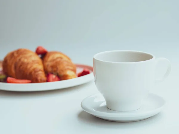 Desayuno de verano con dos croissants, fresas frescas y una taza de café. Primer plano sobre un fondo blanco — Foto de Stock