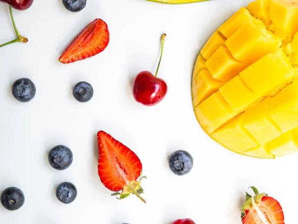 Vista superior coloridas frutas de verano. Acostado plano con mango, fresa y cereza sobre fondo blanco — Foto de Stock
