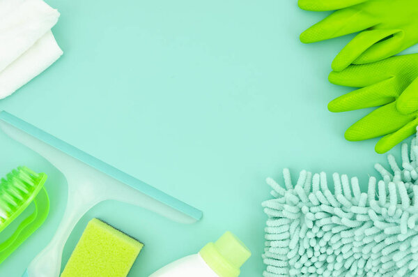 Top view mockup green cleaning supplies isolated on blue background. Flat lay frame with copy space