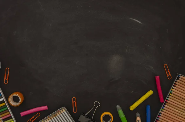 De vuelta a la escuela. Plancha plana maqueta de papelería, bloc de notas, lápices y clips sobre la pizarra del aula con espacio para copias —  Fotos de Stock