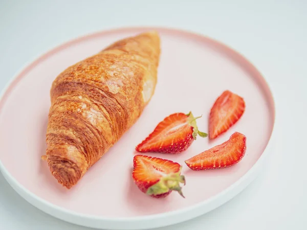 Desayuno para mujeres. Placa rosada con croissants y rodajas de fresa. Primer plano — Foto de Stock