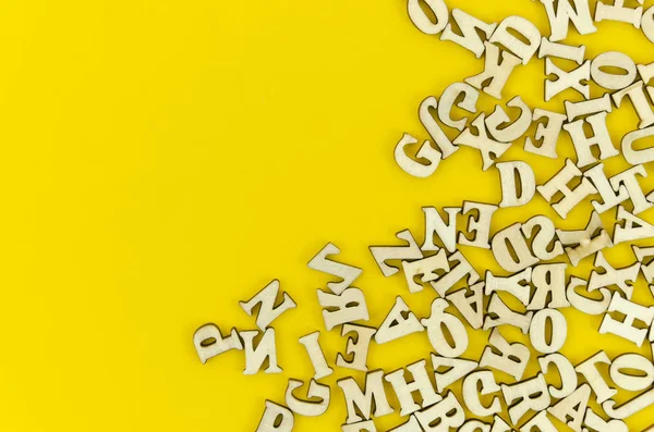 Lettere latine in legno incorniciate in alto su sfondo giallo. Modello flat lay con spazio di copia per il testo — Foto Stock