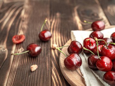Ahşap bir arka plan üzerinde bir tabakta Closeup yaz tatlı kırmızı kiraz