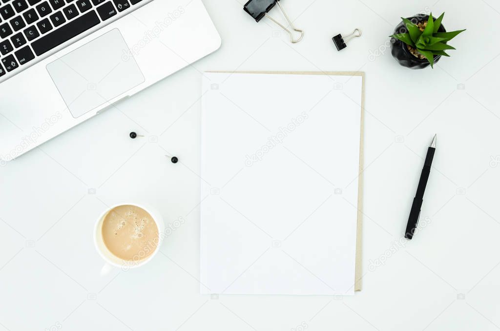 Office desk table with computer, supplies, cup of coffee and blank A4 paper list. White background. Coffee break, ideas, notes, goals or plan writing concept. Top view, flat lay with copy space