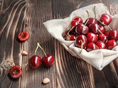 Koyu ahşap arka plan üzerinde bir tabakta Closeup taze tatlı kiraz