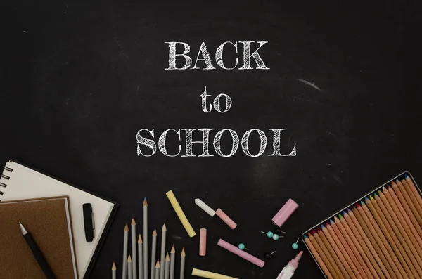 Flach lag das Schulschild mit Schreibwaren, Notizblöcken und Bleistiften über der Schultafel — Stockfoto