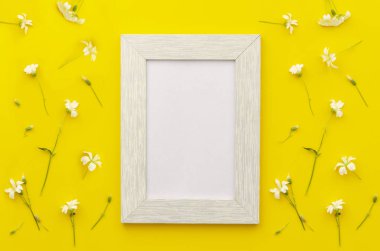 Sarı bir arka planda yaz çiçekler ile çerçeve mockup. Kopya alanı ile düz yatıyordu