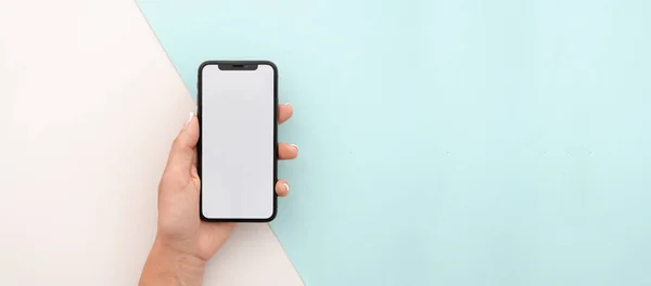 Man hand holding the black smartphone X with big blank screen and modern frame less design. Top view travel mockup horizontal banner — Stock Photo, Image