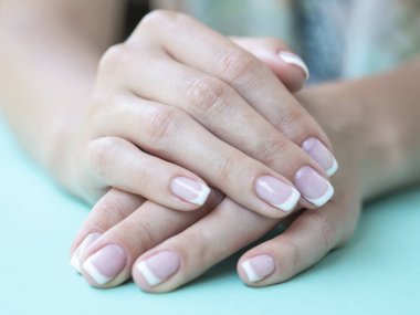 Bir güzellik salonunda kadın Fransız manikür closeup. Güzellik kadın çivi üzerinde bir Mint arka plan