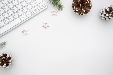 Bilgisayar, çam dalları ve Noel süslemeleri ile üst görünüm ev ofis masası. Beyaz kopya alanı ile düz yatıyordu. Noel konsepti