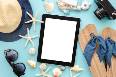 En iyi manzara yaz deniz tatili konsepti. Kadın güneş gözlüğü ve mavi bir arka plan üzerinde palmiye yaprağı ve hasır şapka ile bikini. Tablet pc ortasında, boş ekran mockup