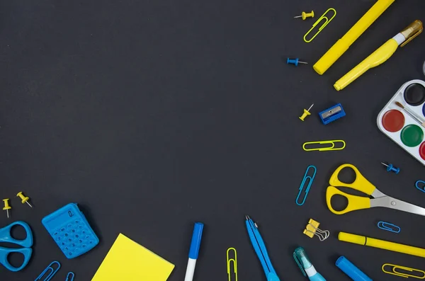 Вид зверху на шкільну концепцію, макет кадру з копіювальним простором, синьо-жовтими ручками з фетру, паперовими затискачами, ножицями, лінійкою. Канцелярські товари на фоні дошки — стокове фото