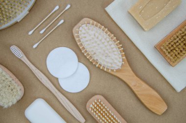 Üst görünüm sıfır atık banyo aksesuarları, doğal sisal fırça, ahşap tarak, katı sabun. Bej zanaat arka plan