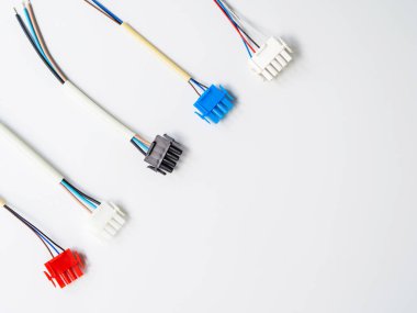 Düz kopya alanı ile beyaz bir arka plan üzerinde birkaç renkli tel konektörler ve teller yatıyordu