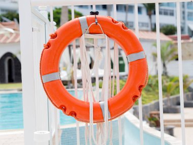 Beyaz bir havuz çit üzerinde Closeyp turuncu lifebuoy