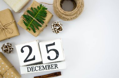 Üst görünüm 25 Aralık için bu beyaz ahşap bloklar takvim ile Noel günü için Tarih kaydedin, beyaz bir arka plan üzerinde mevcut hediyeler ile. Metin için kopyalama alanı ile düz yatıyordu mockup