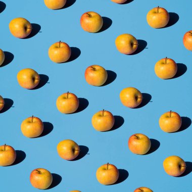 Açık mavi arka planda taze elma pop deseni. Isometrik sert gölgeler. Bio taze meyve suları kavramı